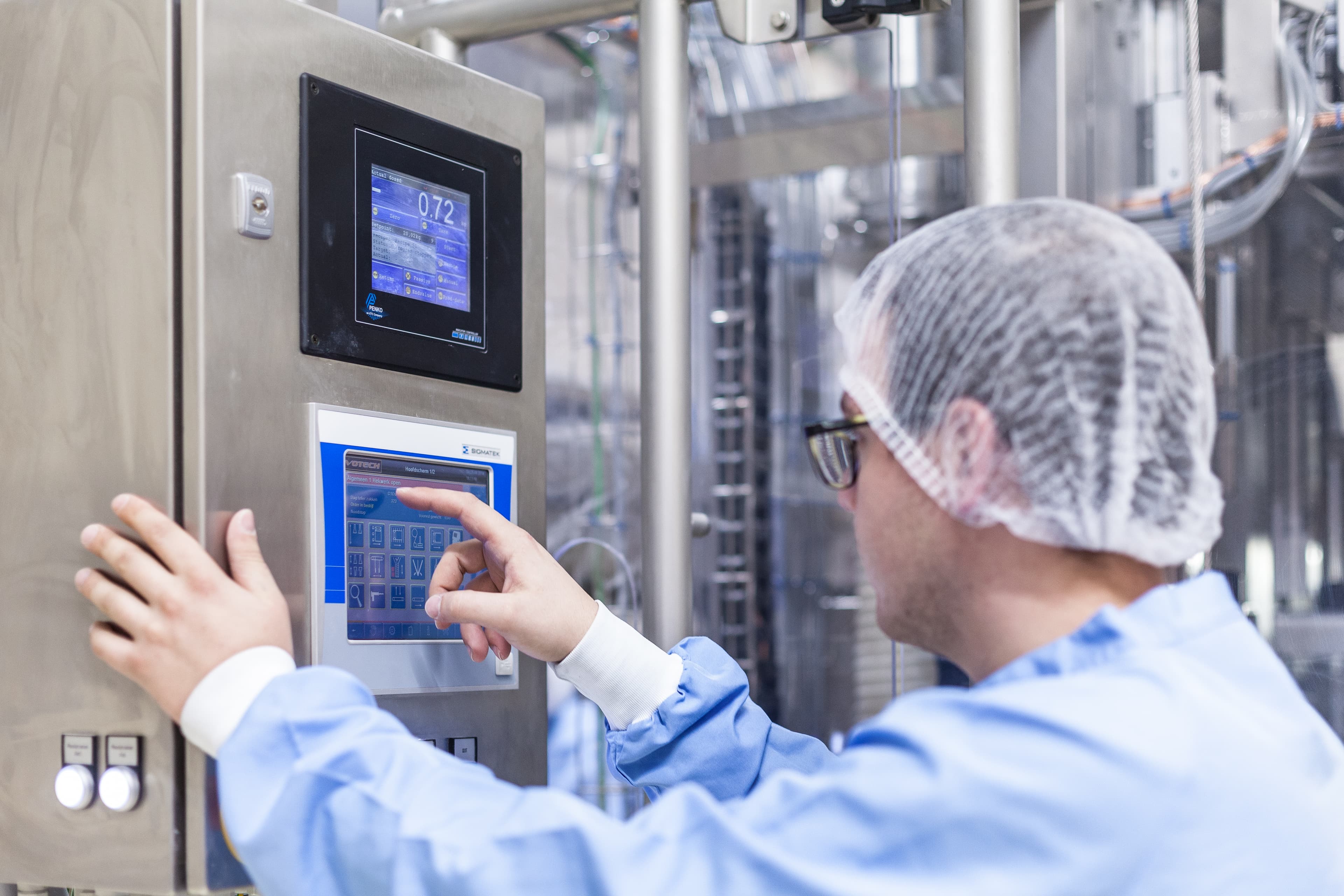 Buisman-medewerker controleert en registreert een productieproces via het bedieningspaneel